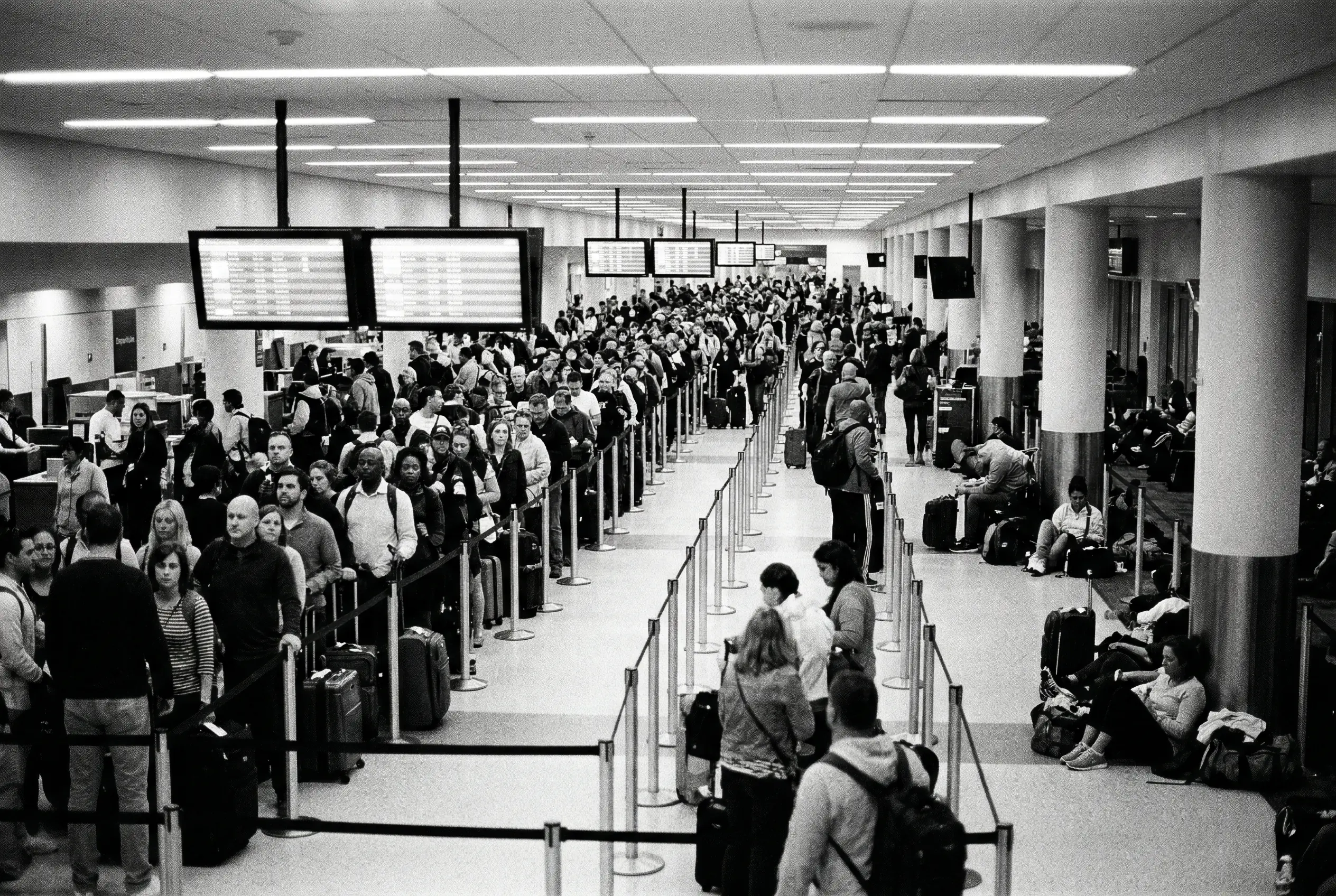 Crowded commercial airport terminal with long security queues and delays